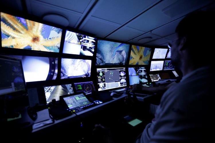 ROV pilot monitoring live subsea camera and sonar feeds in a control room