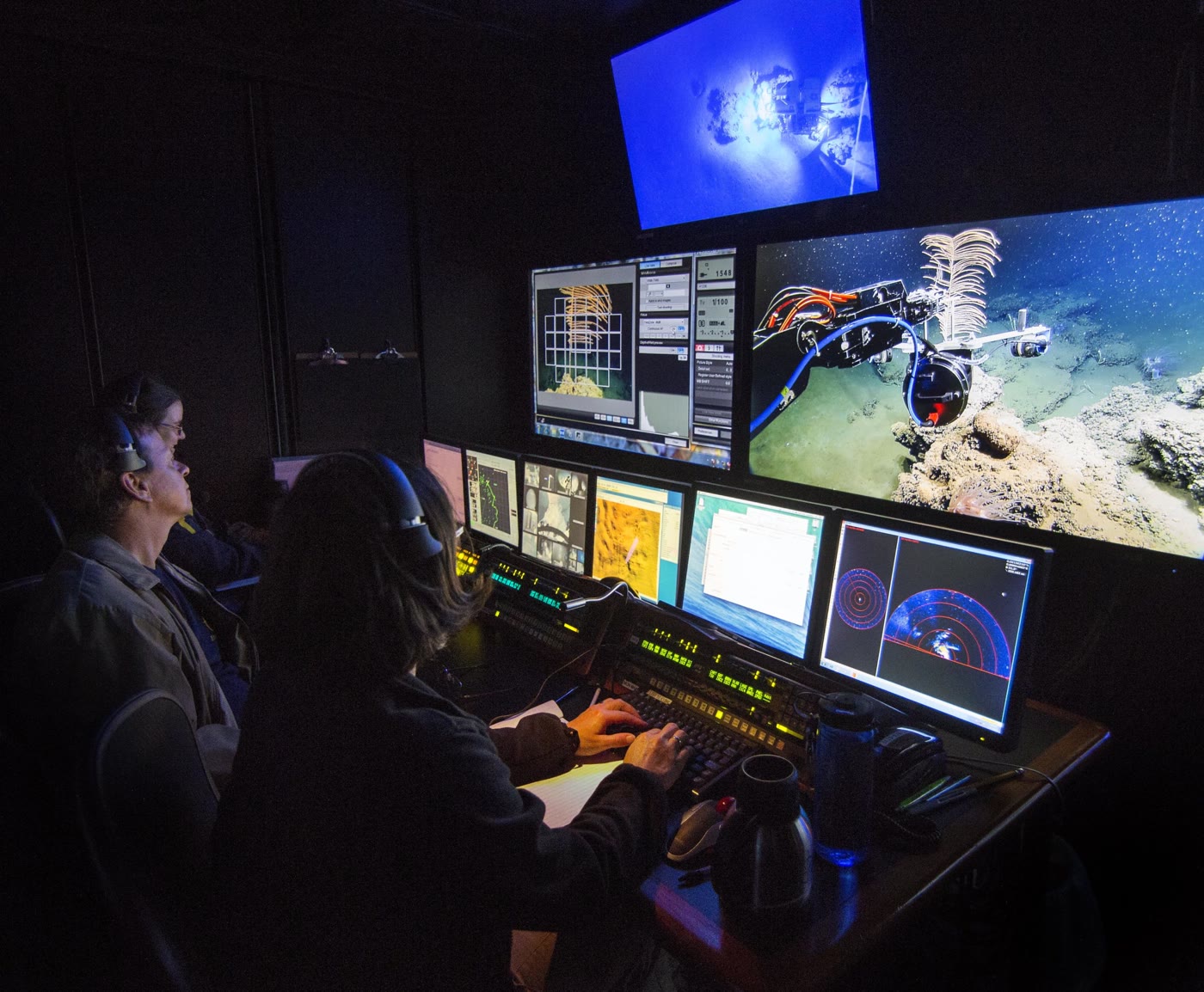 ROV pilot technicians monitoring subsea camera feeds and sonar in a control room